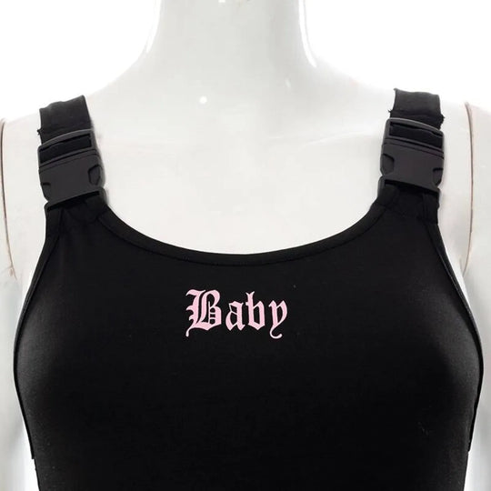 Black 'Baby' cut-out bodysuit with pink lettering and chunky buckled shoulder straps.