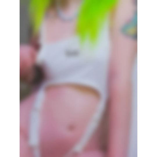 Model in a white cut-out bodysuit with neon green hair, midriff exposed.